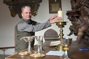 Ein Mann zündet eine Kerze auf einem Altar an