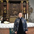 Eine junge Frau mit Brille und kurzen dunklen Haaren steht vor einem Altar