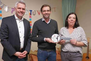 Zwei Männer und eine Frau mit einem großen Schlüssel