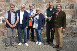 Eine Gruppe von Menschen steht vor einer Kirche.