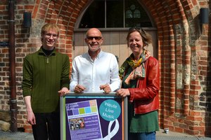 Eine Frau und ein Mann stehen vor dem Eingang zu einer Kirche.