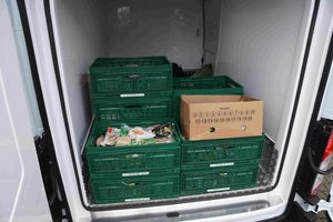 Grüne Kisten und ein Karton im Laderaum eines Fahrzeugs