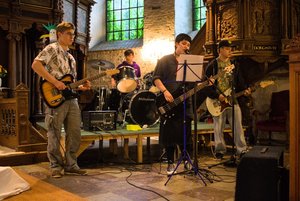 Vier Jugendliche mit Musikinstrumenten in einer Kirche