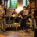 Vier Jugendliche mit Musikinstrumenten in einer Kirche
