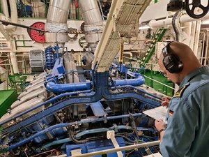 Ein Mann mit Kopfschützern in einem Maschinenraum