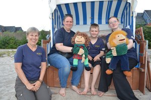 Drei Frauen und ein Junge sind am Strand.