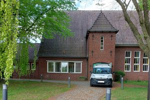 Ein Kirchgebäude. Davor steht ein Auto.