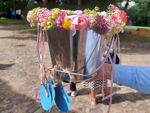 Ein Metalleimer mit Blumen geschmückt.