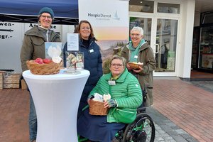 Vier Menschen an einem Stehtisch, davon eine Frau in einem Rollstuhl