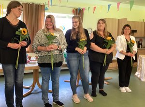 Fünf Frauen halten Sonnenblumen in der Hand