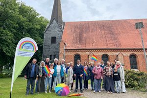 Menschen stehen vor einer Kirche. 