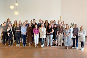 Menschen stehen in einer Kirche. 