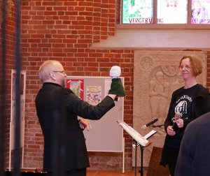 Ein Mann hält eine Handpuppe in Richtung einer Frau