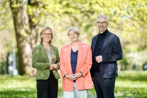 Zwei Frauen und ein Mann in einem Park bei Sonnenschein