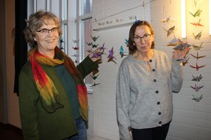 Zwei Frauen zeigen gebastelte Kranichketten