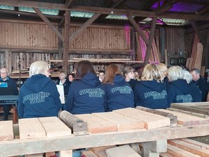 Mehrere Menschen mit gleich aussehenden Oberteilen sitzen nebeneinander