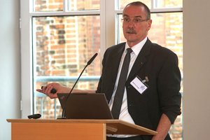 Ein Mann im Anzug steht an einem Rednerpult.